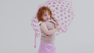 a red head child is playing with an umbrella